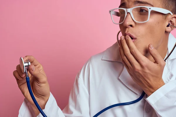 Joven médico con un estetoscopio y gafas en un fondo rosa enfermera pasantes modelo —  Fotos de Stock