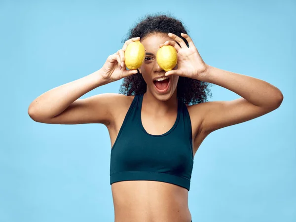 Sportliche Frau im T-Shirt hält Zitronen in der Hand — Stockfoto