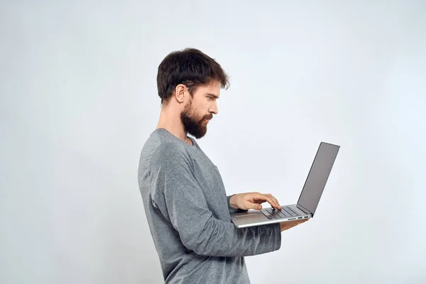 Bearded man with laptop in hands internet communication technology light background