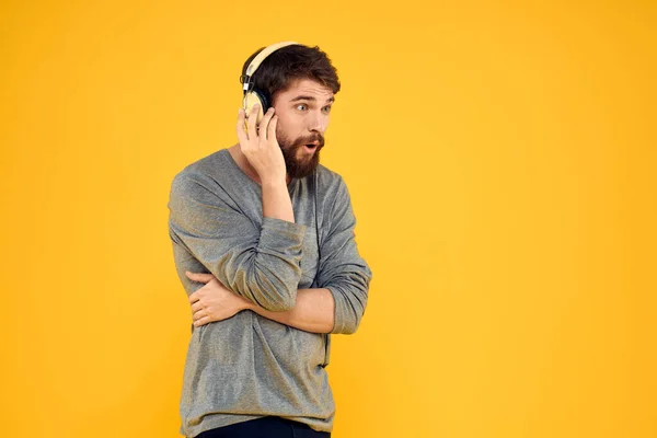 Hombre en auriculares escucha música tecnología estilo de vida gente divertida fondo amarillo — Foto de Stock