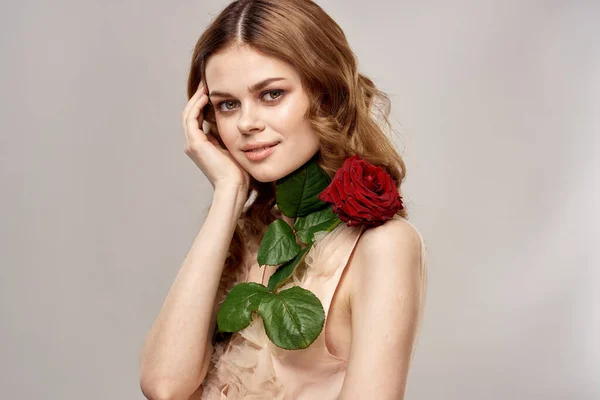Rudowłosa kobieta z różą w rękach na lekkim tle emocje model portret zbliżenie — Zdjęcie stockowe