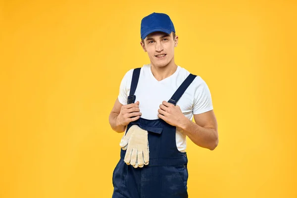 Hombre en uniforme de trabajo emociones prestación de servicio de entrega de fondo amarillo — Foto de Stock