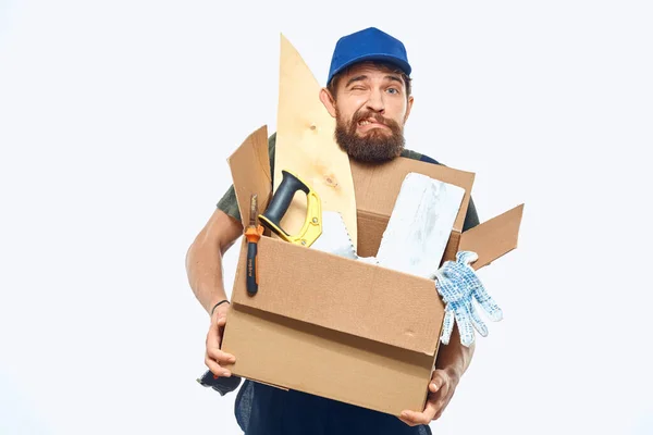 Trabajador hombre en uniforme con una caja en sus manos herramientas entrega servicio luz fondo —  Fotos de Stock