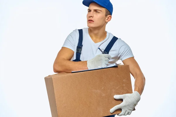 Muž pracovník s krabicí v ruce dodávka nakládka služby práce světlo pozadí — Stock fotografie