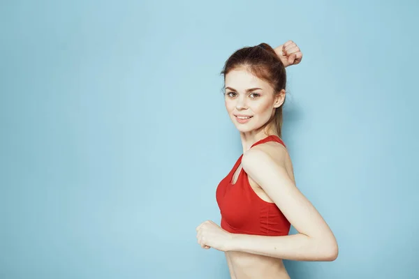 Sportiv kvinna röd tank top workout livsstil gym blå bakgrund — Stockfoto