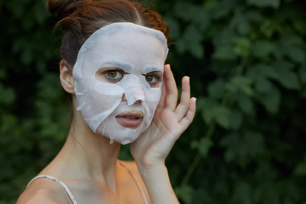 Wanita cantik topeng putih tangan dekat wajah Copy Space kosmetologi semak di latar belakang — Stok Foto