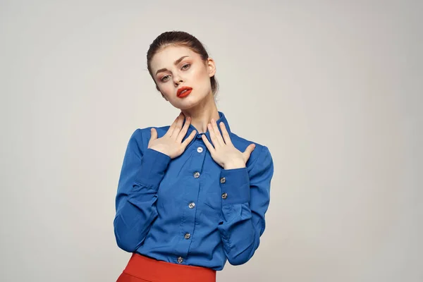Portret van een mooie vrouw met rode lippen op een lichte achtergrond en een blauw shirt bijgesneden uitzicht — Stockfoto