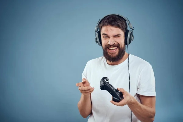 Homme en casque contrôleur dans les mains jeu console style de vie émotions bleu fond blanc t-shirt — Photo