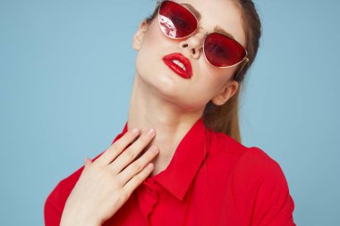 Gözlüklü ve kırmızı dudaklı bir kadının portresi. Mavi arka plan modeli.