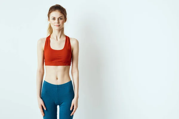 Mujer deportiva pose gimnasia equilibrio ejercicio luz fondo — Foto de Stock