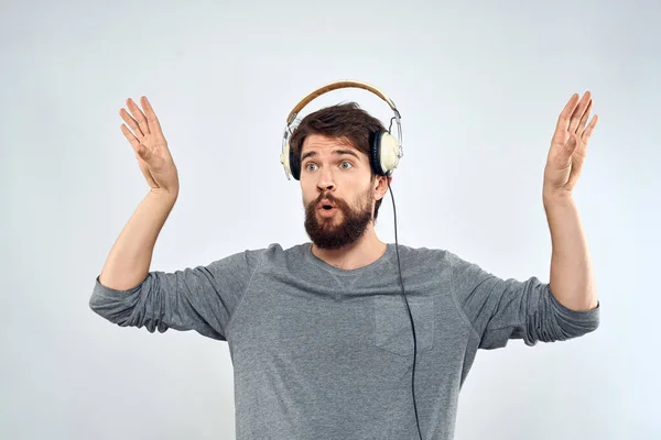 Ο άνθρωπος με ακουστικά ακούει μουσική lifestyle σύγχρονο στυλ τεχνολογίας φως φόντο — Φωτογραφία Αρχείου