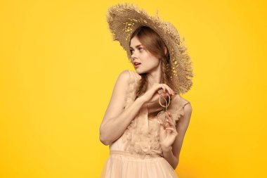 Şapkalı ve elbiseli bir bayan. Kızıl saçlı, sarı arka planlı, model portresi eğlenceli.