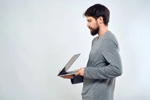 Um homem com uma camisola cinza com um laptop mãos estilo de vida tecnologia comunicação internet trabalho — Fotografia de Stock