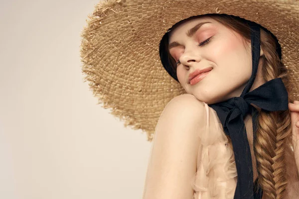 Menina agradável em um chapéu de palha com uma fita preta e em um vestido em um fundo leve romance modelo diversão emoção — Fotografia de Stock