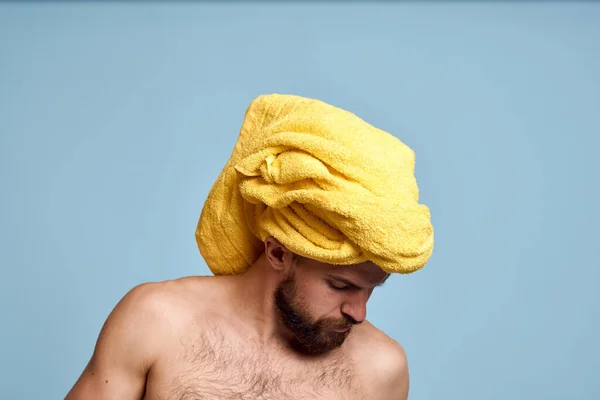 Homem com ombros nus toalha amarela em sua cabeça algodão cotonetes cuidados de higiene — Fotografia de Stock