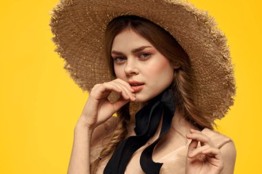 Sarı arka planda saman şapkalı portre kadın. Yazlık elbise mankeni romantizmi.