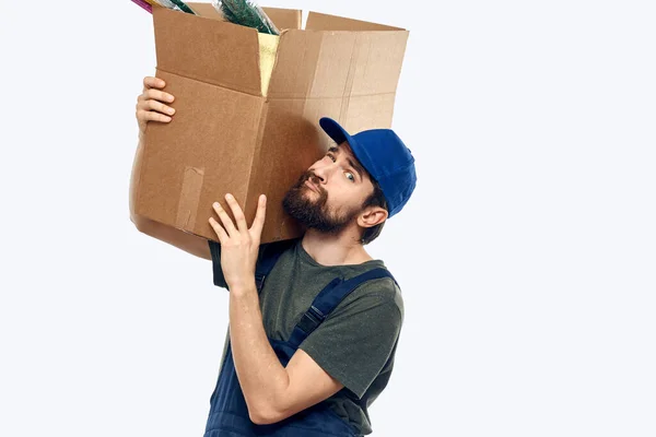 A man in a working uniform with a box in his hands delivery transportation work — Stock Photo, Image