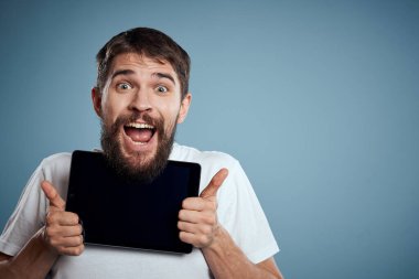 Tabletli bir adam mavi arkaplanda yüzün yanında kırpılmış görünüm dokunmatik izleme yeni teknolojileri kopyala