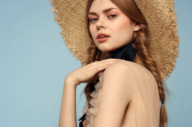 Gri arka planda hasır şapkalı romantik bir kız ve bej renkli bir elbise siyah kurdele duygu modeli.