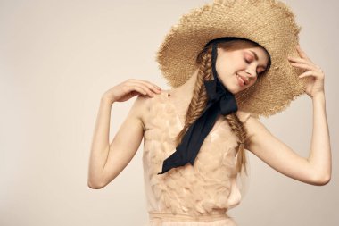 Şapkalı ve arka planda giyinmiş romantik bir kadın elleriyle komik duyguların portresini çiziyor.