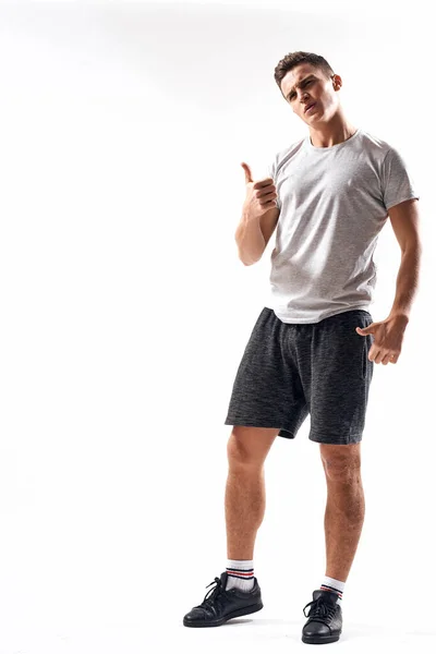 Athletic man på en lätt bakgrund i full tillväxt och jogging laddning shorts sneakers t-shirt — Stockfoto