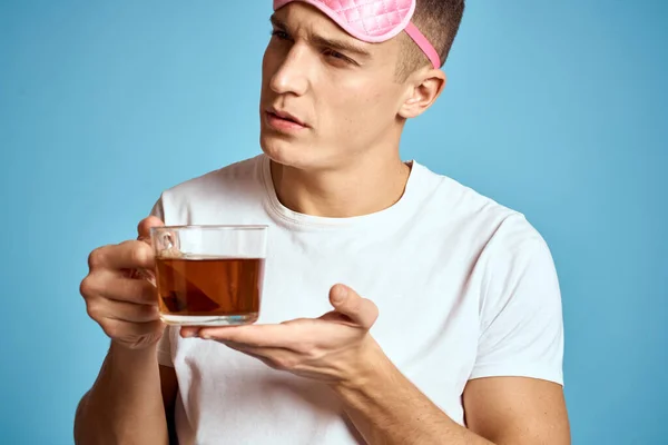 Uomo con maschera rosa del sonno e tazza di tè bere allegria modello colazione — Foto Stock