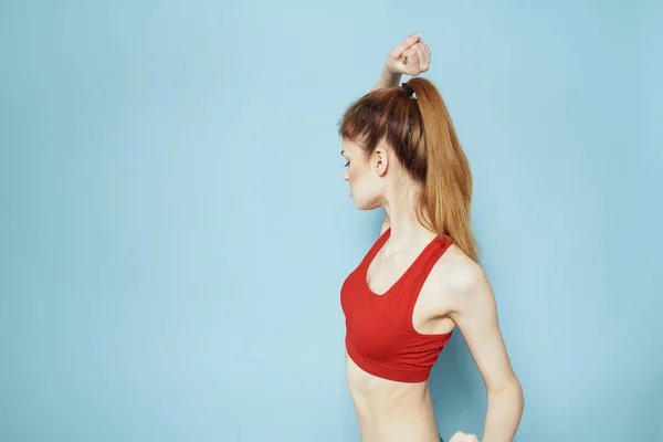 Donna sportiva serbatoio rosso allenamento stile di vita palestra sfondo blu — Foto Stock