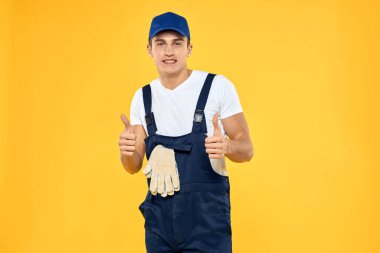 Çalışan üniformalı adam duygularını servis hizmeti sarı arka planda sunuyor