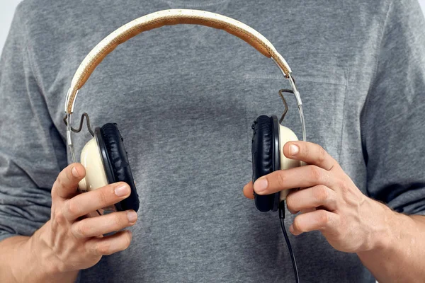 Hombre sosteniendo los auriculares en las manos de un hombre estilo de vida moderna tecnología recortada vista —  Fotos de Stock