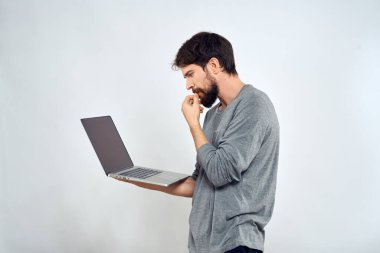 Elinde dizüstü bilgisayarı olan sakallı bir adam internet iletişimi teknolojisi ışık arka planı