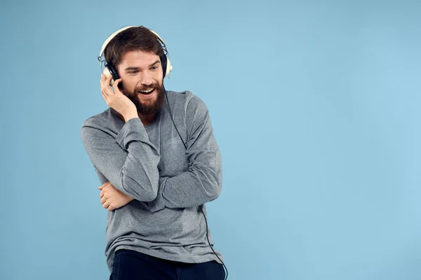 Hombre usando auriculares música emoción estilo de vida moderno estilo tecnología azul fondo —  Fotos de Stock