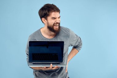 Sakallı adam dizüstü bilgisayarı elinde internet kablosuz teknoloji duyguları mavi arka plan