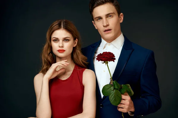Mladý pár objetí kouzlo červená růže vztah černý pozadí — Stock fotografie
