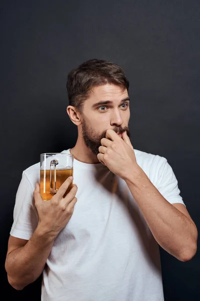 Мужчина с кружкой пива в белой футболке эмоции образа жизни пьяный на темном изолированном фоне — стоковое фото