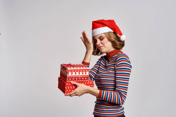 Щаслива жінка з різдвяними подарунками в руках і червоним капелюхом на голові новорічні свята обрізаний вид — стокове фото