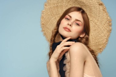 Gri arka planda hasır şapkalı romantik bir kız ve bej renkli bir elbise siyah kurdele duygu modeli.