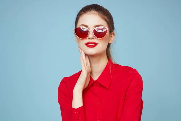 Beautiful woman in dark glasses red shirt bright makeup emotions attractive look blue background — Stock Photo, Image