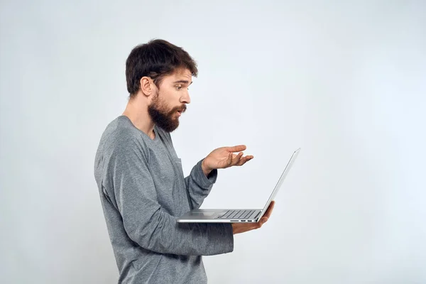 Muž držící notebook internet komunikace životní styl technologie světlo pozadí studio — Stock fotografie