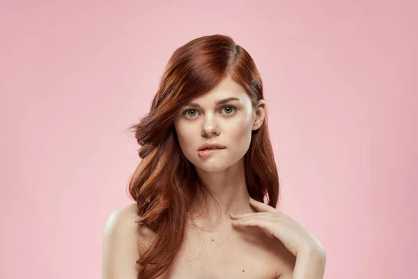 Bella donna con lunghi bei capelli toelettatura acconciatura glamour spalle nude sfondo rosa — Foto Stock