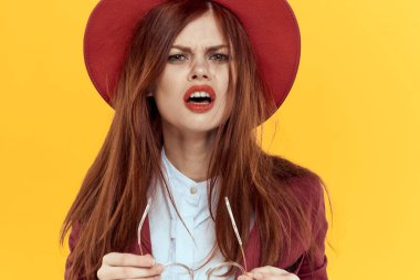 Kırmızı şapkalı kadın gözlükleri sarı arka plan kozmetik