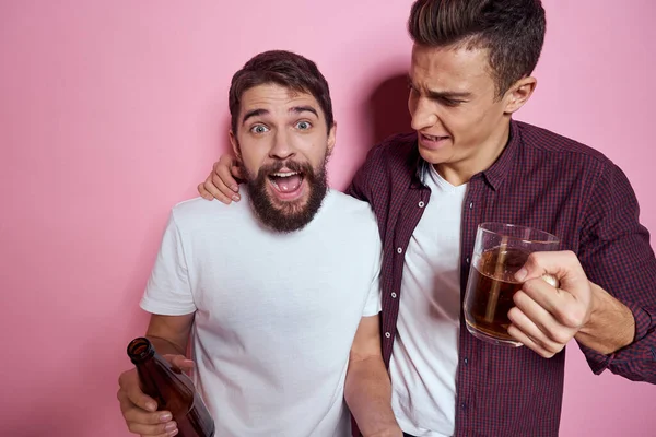 Dwóch mężczyzn pije piwo przyjaźń pijany alkohol styl życia różowy tło — Zdjęcie stockowe