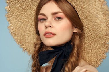 Hasır şapkalı kız portresi yakın çekim at kuyruğu eğlenceli kızıl saçlı mavi arka plan