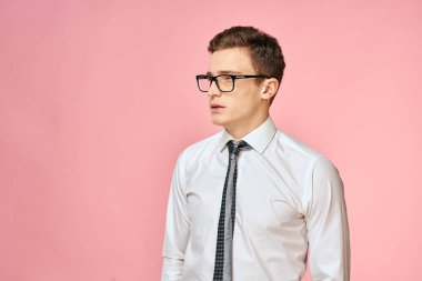 Beyaz gömlekli, kravatlı, gözlüklü, kendine güvenen, resmi pembe arka planlı bir iş adamı.