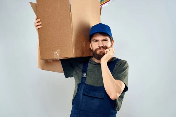 Homem em uniforme de trabalho com caixas em mãos entrega carregamento estilo de vida — Fotografia de Stock