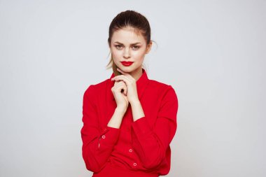 Açık arkaplanda kırmızı dudaklı bir kadının portresi. Makyaj modeli.