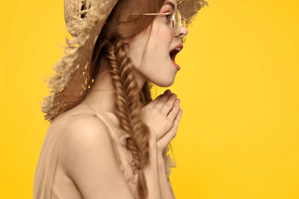 Porträtt av en vacker kvinna med flätor och med en hatt på huvudet på en gul bakgrund beskuren vy — Stockfoto