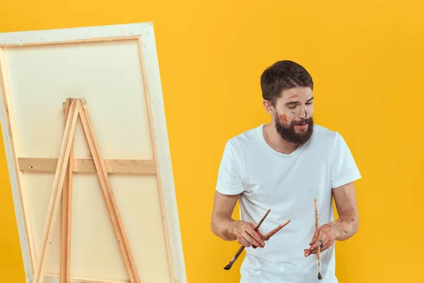 Male artist stands in front of easel emotions drawing Creative approach yellow