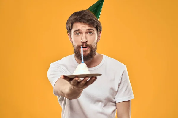 Cumpleañero en una gorra con pastel divertido amarillo fondo partido —  Fotos de Stock