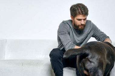 Kanepede evcil köpeği olan bir adam. Arkadaşlarıyla eğleniyor.