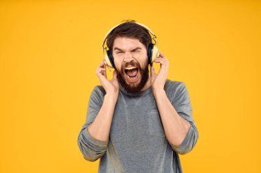 Kulaklıklı bir adam müzik, yaşam tarzı teknolojisi, sarı arka plan.